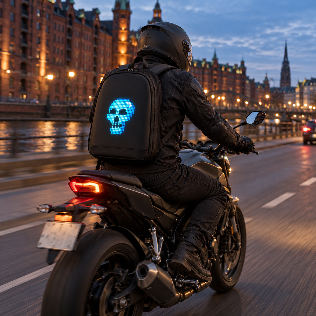 PIXLII Spectra 64 LED-Rucksack in Schwarz mit leuchtendem Totenkopfmotiv bei einer Motorradfahrt am Abend