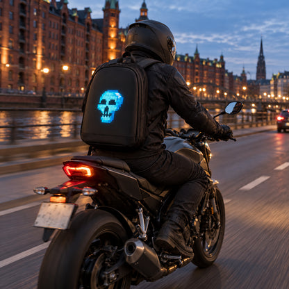 PIXLII Spectra 64 LED-Rucksack in Schwarz mit leuchtendem Totenkopfmotiv bei einer Motorradfahrt am Abend